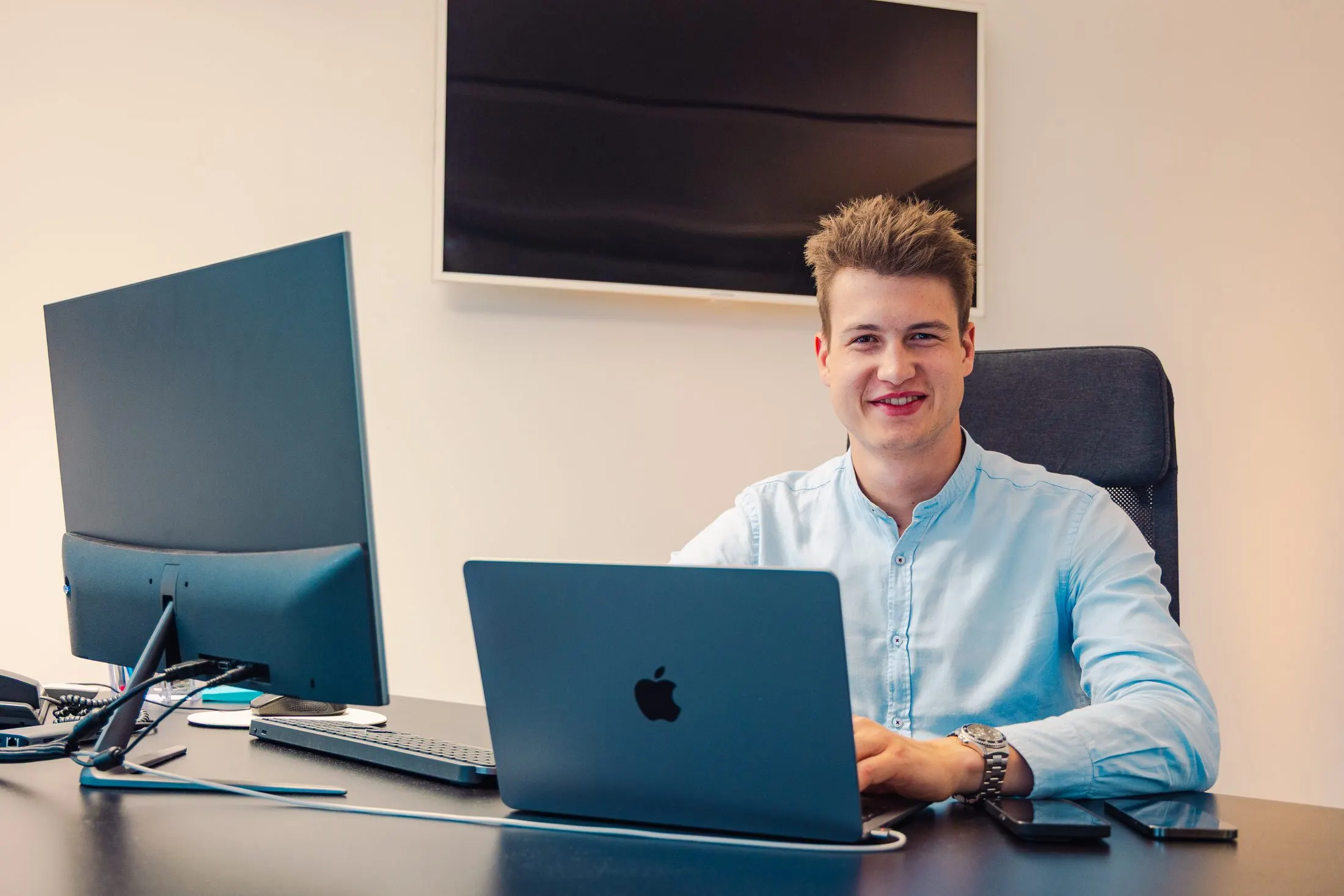Kaino developer at his desk with a laptop and monitor